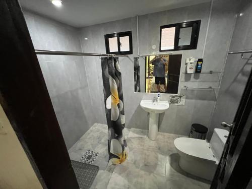 uma casa de banho com um lavatório e um WC em Adayo Cove Resort em Siquijor