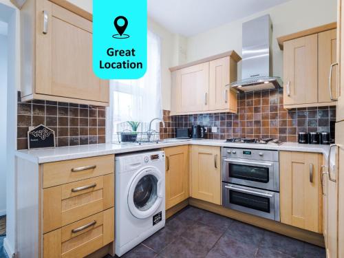 a kitchen with wooden cabinets and a washing machine at Stunning Spacious 2BR House in East Ardsley 