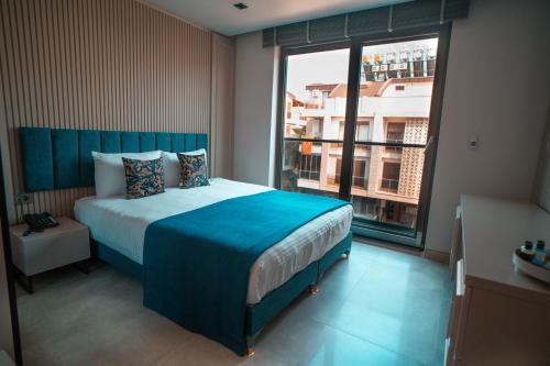 - une chambre avec un grand lit et une grande fenêtre dans l'établissement Sam Hotel, à Antalya