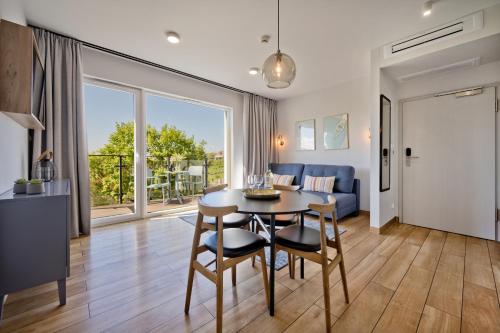 een eetkamer en een woonkamer met een tafel en stoelen bij Aparthotel Anchoria BlueApart in Mechelinki