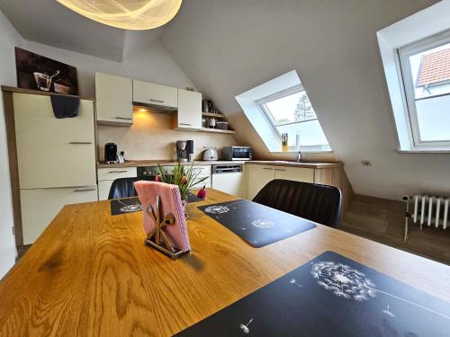 een keuken met een houten tafel met daarop een laptop bij Design Apartment Grünwald große Wohnung auf 2 Etagen in Hahnenklee-Bockswiese