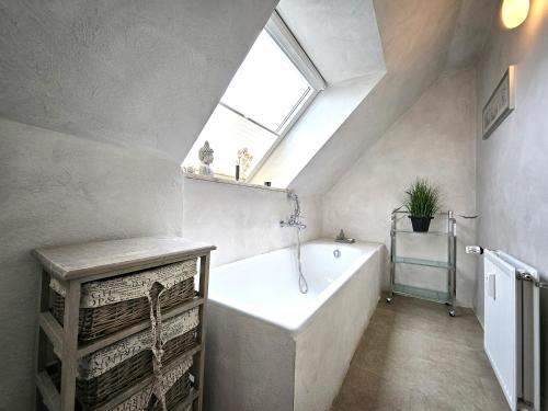 een badkamer met een groot bad en een raam bij Design Apartment Grünwald große Wohnung auf 2 Etagen in Hahnenklee-Bockswiese