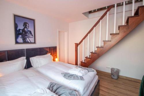a bedroom with a bed and a staircase at Hotel Dona in Bergisch Gladbach