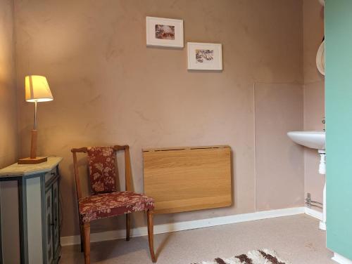 a bathroom with a chair and a sink at Brukshotellet Öland - kursgård och vandrarhem in Degerhamn