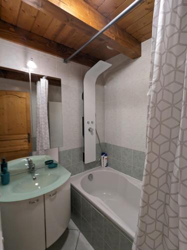 une salle de bain avec un lavabo et une baignoire dans l'établissement Petite maison de village située entre lacs, cascades et montagnes, à Virieu-le-Grand