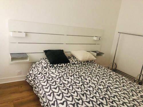 Un dormitorio con una cama con dos almohadas encima. en BizFinding Paris, en Montrouge