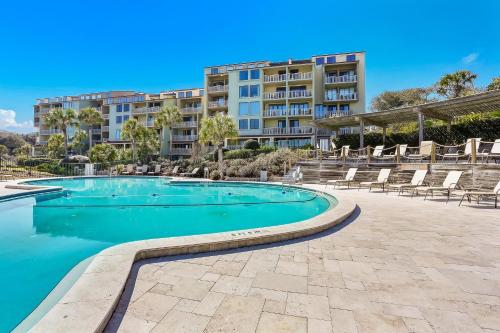 a swimming pool with chairs and a building at 1379 Shipwatch in Amelia Island