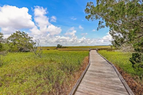 a wooden path through a field with a blue sky at 1379 Shipwatch in Amelia Island