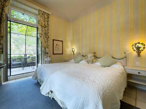 a bedroom with a large bed and a balcony at Ristorante della Stazione da YanElo in Intragna