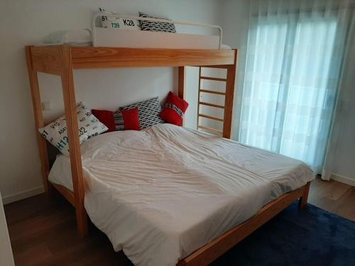 a bedroom with a bunk bed with red pillows at Silver Coast Holiday in Salir de Porto