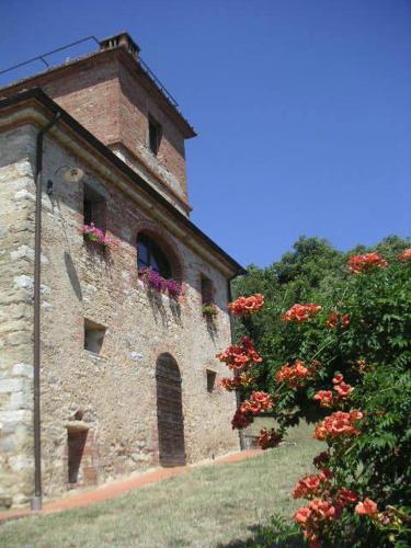 a brick building with flowers on the side of it at Podere Piemonti in Serre di Rapolano