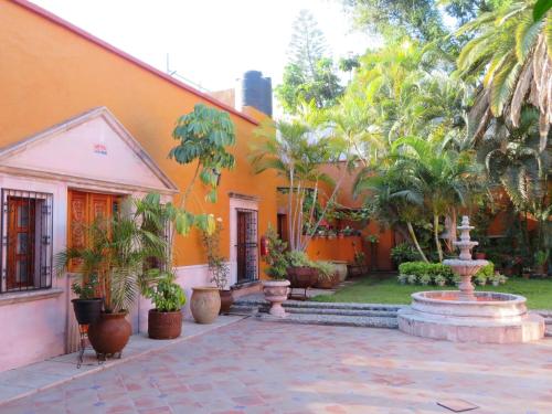 un bâtiment orange avec une fontaine dans la cour dans l'établissement Casa Rosa Amelia, à Guadalajara