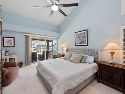 ein Schlafzimmer mit einem großen Bett und einem Deckenventilator in der Unterkunft ELEVATED 106 - Spacious 3 Bedroom Waterside Pool Home in Marco Island