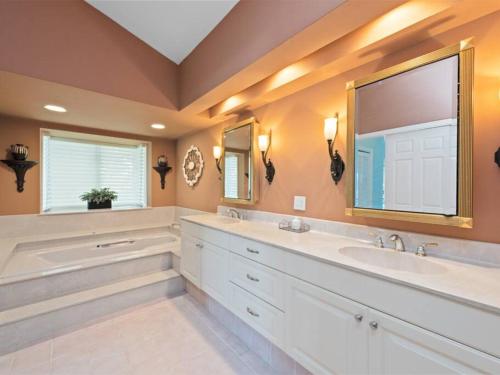 ein Badezimmer mit zwei Waschbecken und einem großen Spiegel in der Unterkunft ELEVATED 106 - Spacious 3 Bedroom Waterside Pool Home in Marco Island