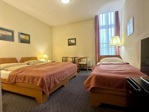 ein Hotelzimmer mit 2 Betten und einem Tisch in der Unterkunft Self Check-in Hotel Am Schottenpoint in Wien