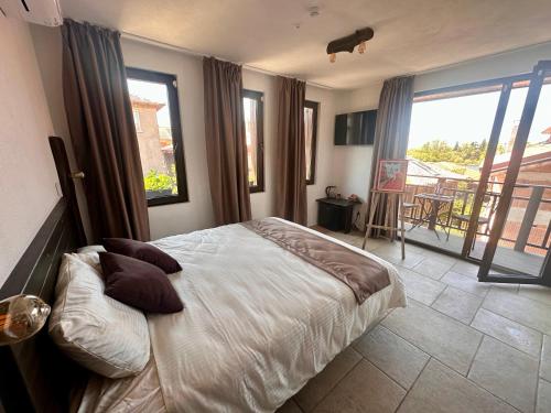 ein Schlafzimmer mit einem großen Bett und einem Balkon in der Unterkunft Arthotel Oscar II Sozopol in Sozopol