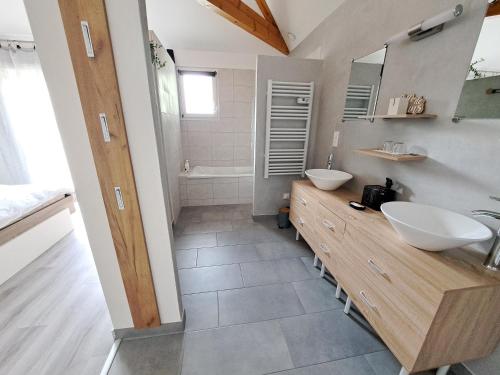 een badkamer met 2 wastafels en een bad bij le chemin des Bérands chambres d'hôtes Renaison in Renaison