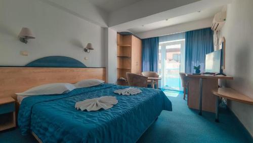 a bedroom with a blue bed with two towels on it at BRIZA Boutique Hotel Mamaia in Mamaia
