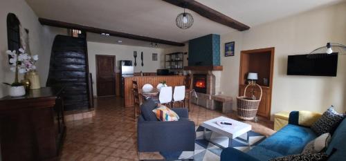 uma sala de estar com um sofá e uma mesa em Maison de l'Echauguette em Mortemart