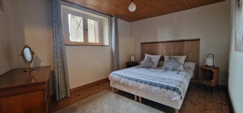 um quarto com uma cama e uma janela em Maison de l'Echauguette em Mortemart