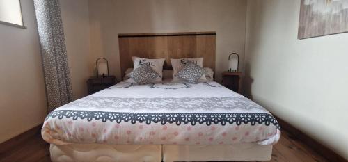 une chambre avec un grand lit et deux lampes dans l'établissement Maison de l'Echauguette, à Mortemart