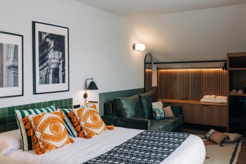 pokój hotelowy z łóżkiem i kanapą w obiekcie Doña Lola Alojamientos Boutique w mieście Lucena