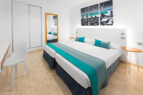 a bedroom with a large bed and a desk at Saint George in Los Cristianos