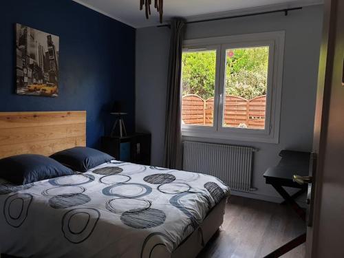 ein Schlafzimmer mit einem Bett und einem Fenster in der Unterkunft Villa indépendante avec piscine in Arès