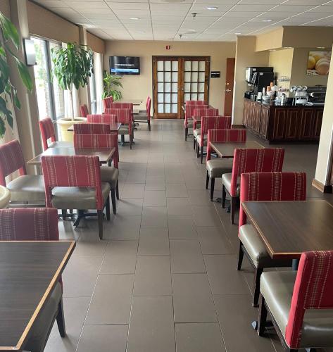 a dining room with tables and red chairs at Ardmore Inn & Suites Ardmore in Ardmore