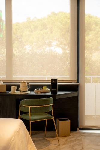 a bedroom with a chair in front of a window at La Duse Luxury Rooms in Pescara