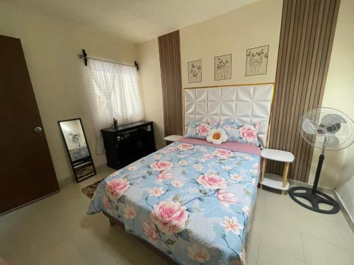 Un dormitorio con una cama con flores rosas. en Casa completa y céntrica en Gómez Palacio, en Gómez Palacio