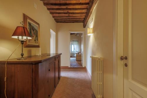 a hallway with a table and a lamp in a room at Hotel Villa Sermolli in Borgo a Buggiano