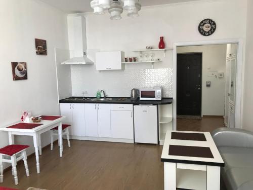 a kitchen with white cabinets and a black counter top at Light Apartments in Chernihiv