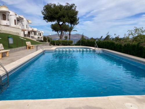una piscina con acqua blu davanti a una casa di El Amanecer de Cabo Tiñoso a Puerto de Mazarrón