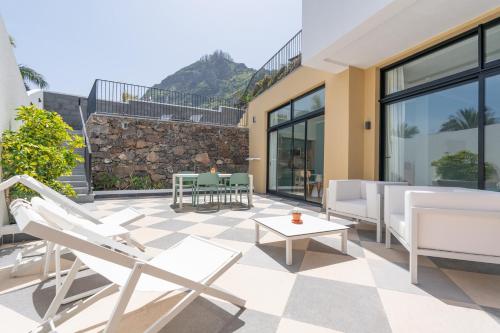 a patio with chairs and a table on a building at Studios by Aqua Natura Hotels in Porto Moniz