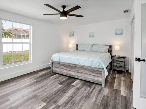 ein Schlafzimmer mit einem Bett und einem Deckenventilator in der Unterkunft ELEVATED 1152 - Serene Family friendly 4 bed pool home in Marco Island