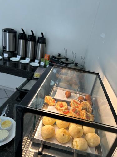 a display case in a kitchen with some food at Nautillus Hotel in Parnaíba