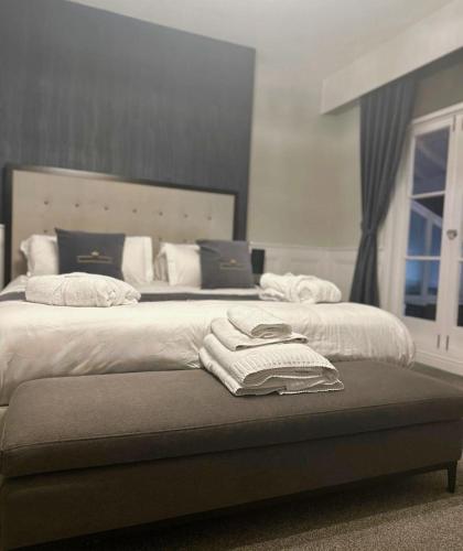 a bedroom with two beds with towels on a bench at The Royal Hotel - Clacton On Sea in Clacton-on-Sea