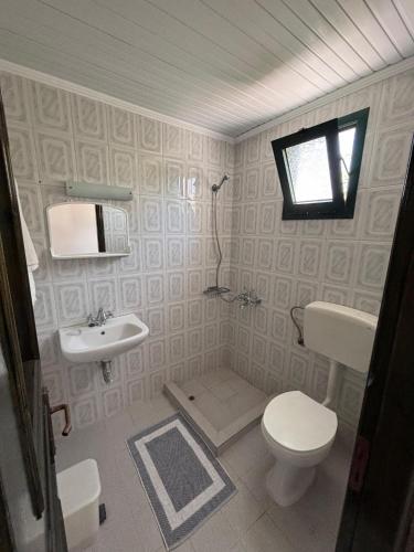 ein Badezimmer mit Toilette und Waschbecken in der Unterkunft Apartments Fotoula in Petra