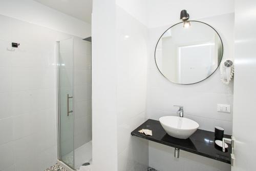 La salle de bains est pourvue d'un lavabo et d'un miroir. dans l'établissement Room 23, à Rome
