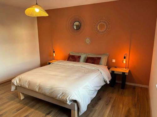 une chambre avec un grand lit avec un mur orange dans l'établissement Gîte du Bretzel, à Wihr-au-Val