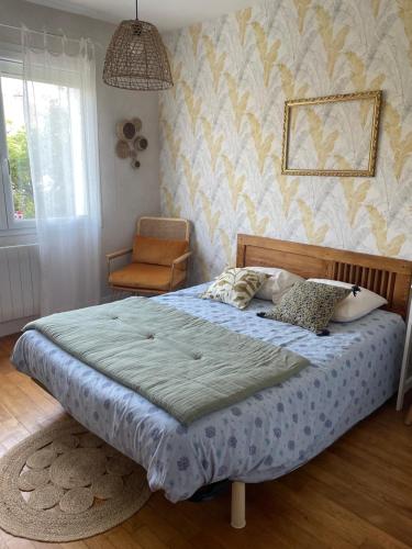 a bedroom with a large bed and a chair at Chambre avec petit dej à 2kms du centre de Nevers in Varennes Vauzelles
