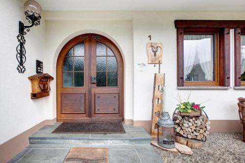 uma casa com uma porta de madeira e uma janela em Haus Kurparkblick em Todtmoos