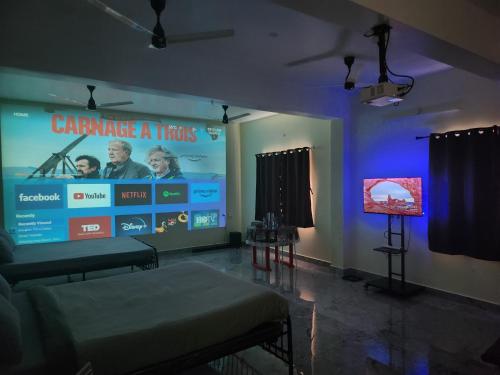 Zimmer mit einem großen Bildschirm, einem Sofa und einem TV in der Unterkunft Elite Resort in Yelagiri