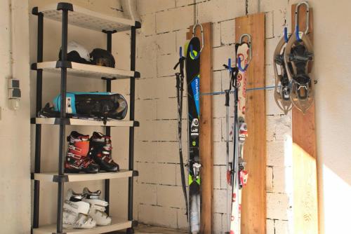 une pièce avec deux étagères avec des skis sur un mur dans l'établissement Escapadelia - Locations pour les sportifs et amoureux de la nature, à Pelvoux