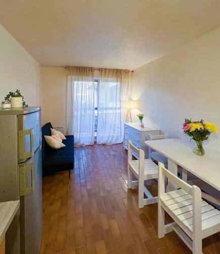 un salon avec une table et un canapé bleu dans l'établissement Charmant appartement à la plage, à Canet