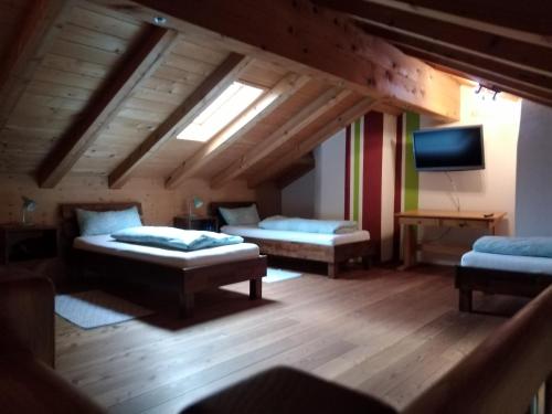 Cette chambre mansardée comprend 2 lits et une télévision. dans l'établissement Arbeiterwohnung Entbuchner Hof, à Rohrdorf
