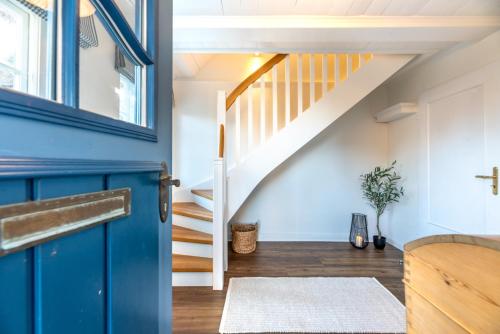 Zimmer mit einer blauen Tür und einer Treppe in der Unterkunft Tide-Hus in Oevenum