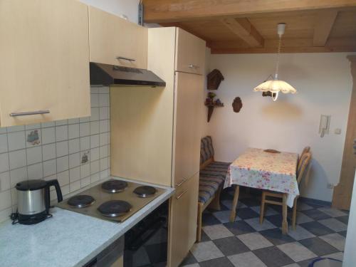 Il comprend une petite cuisine équipée d'une table et d'une cuisinière. dans l'établissement Arbeiterwohnung Entbuchner Hof, à Rohrdorf