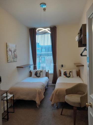 a hotel room with two beds and a window at parkhill guest house in Inverness
